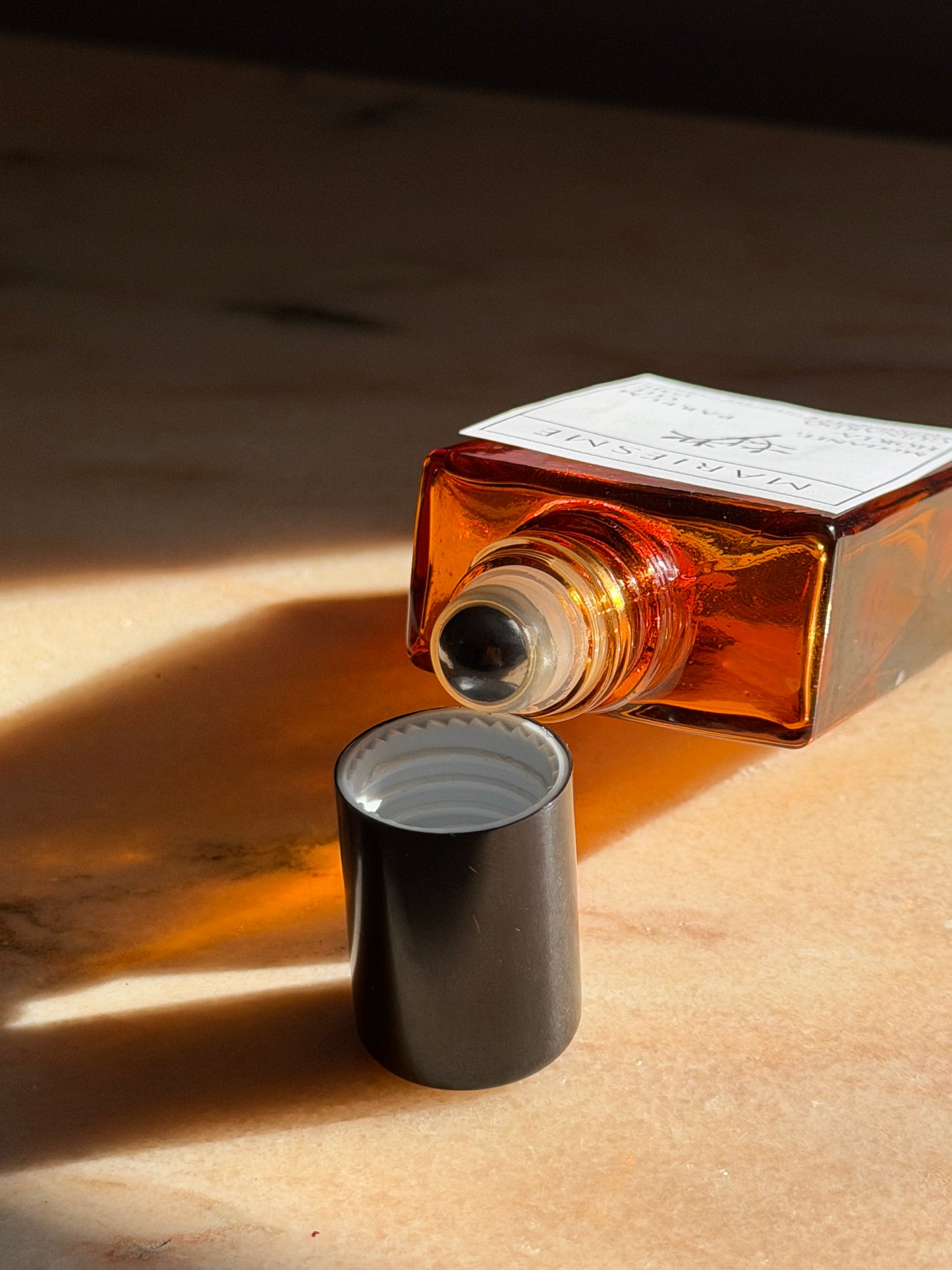 Amber glass bottle with a black cap on a wooden surface